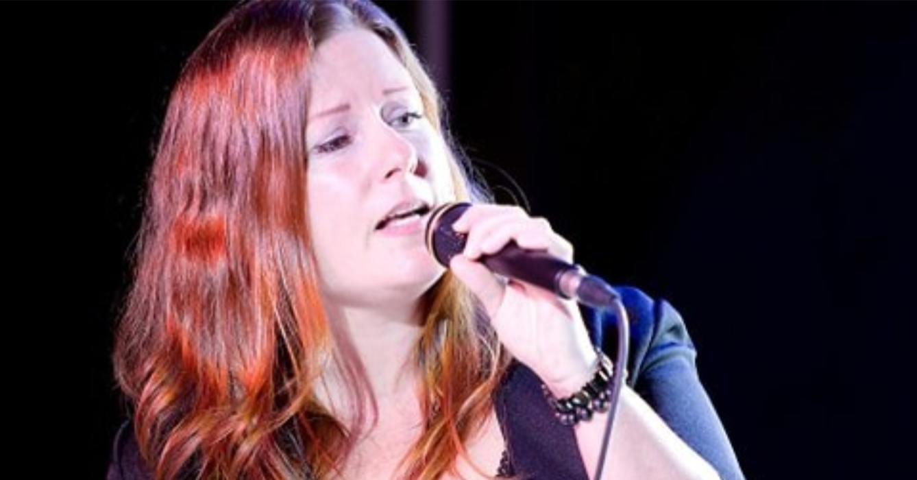 sarah bédard qui chante au micro, fond noir